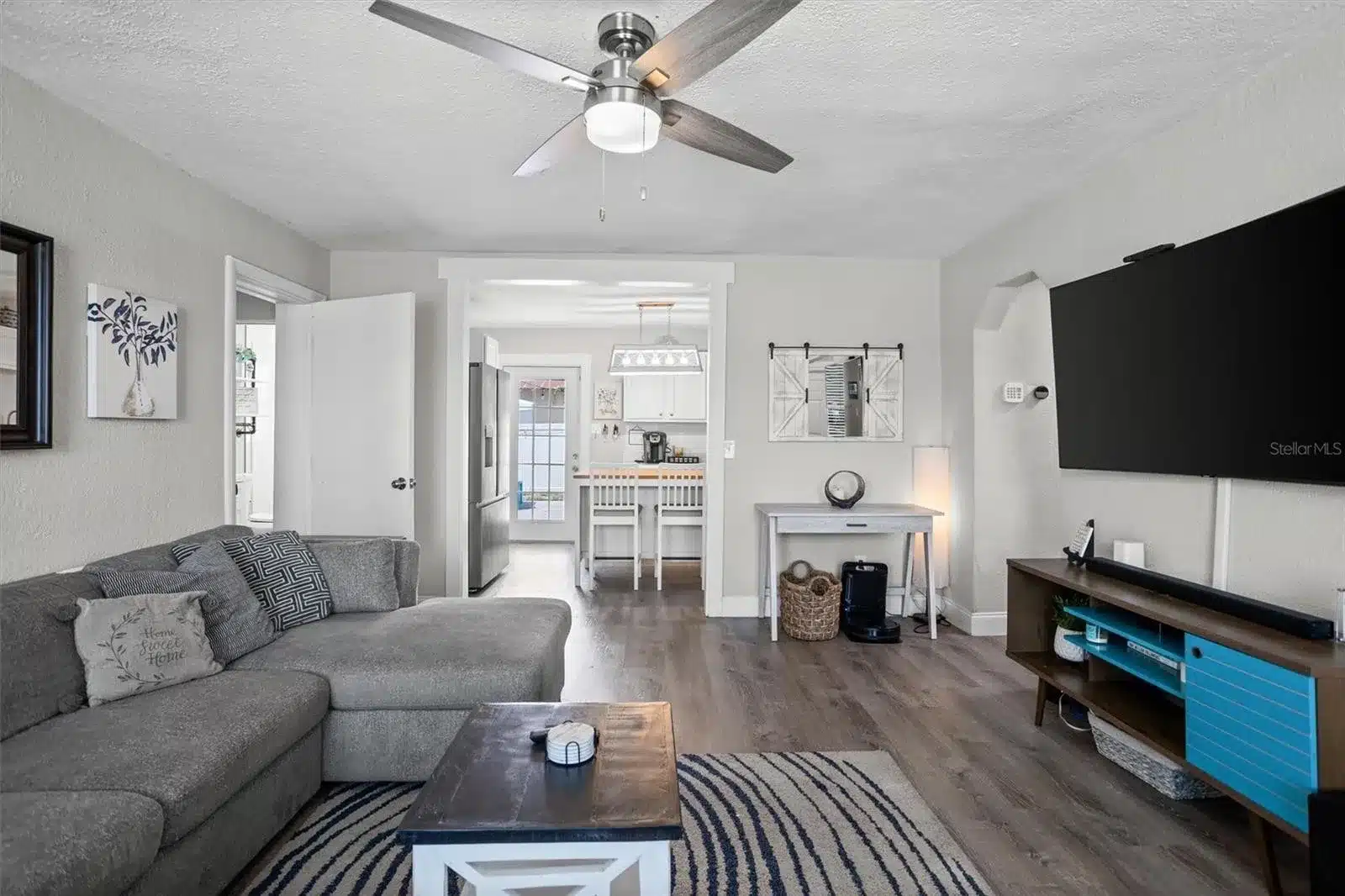 Open living space with kitchen visible in background.
