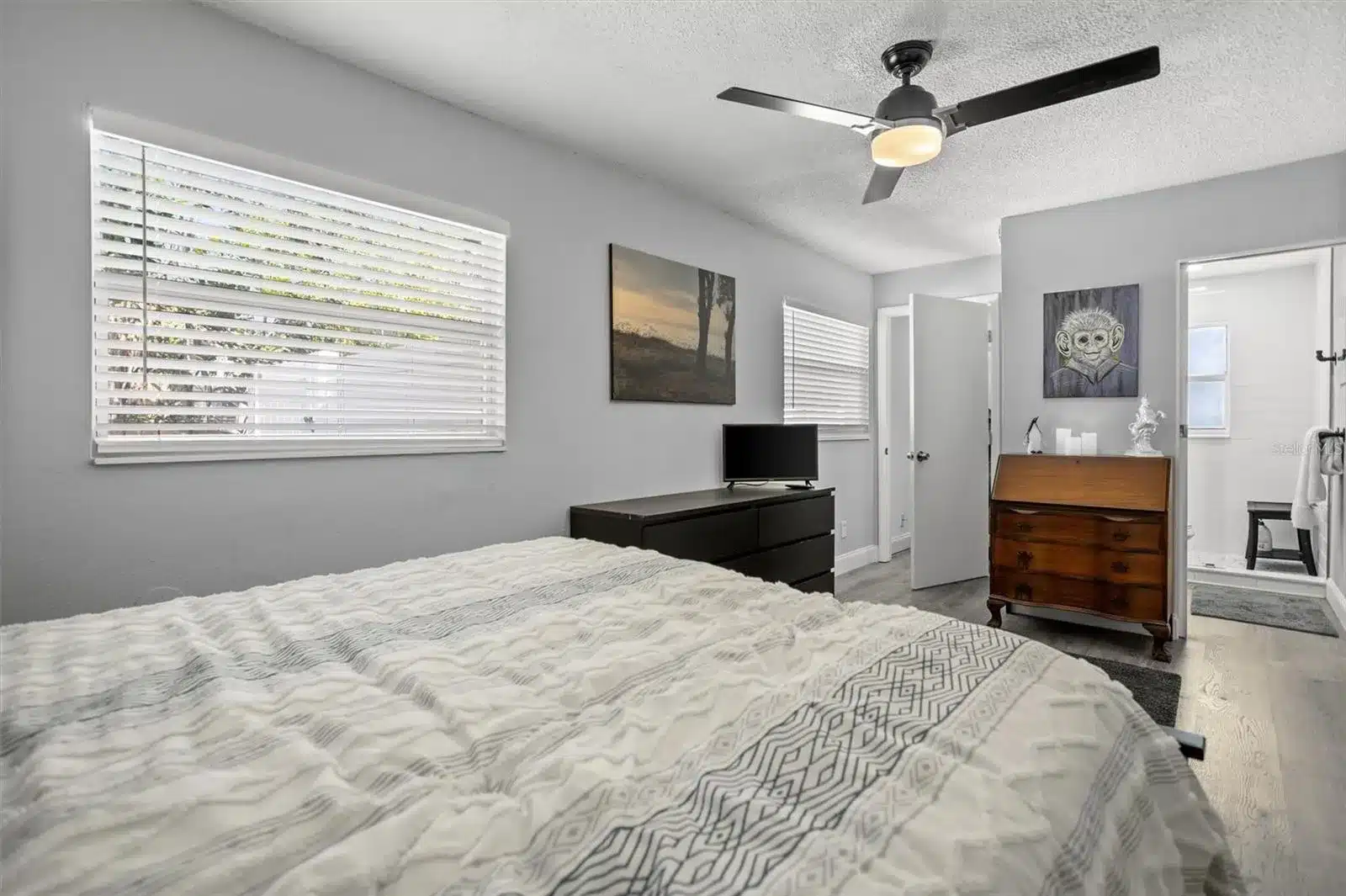 Bedroom with bed, dresser, window, and ceiling fan.