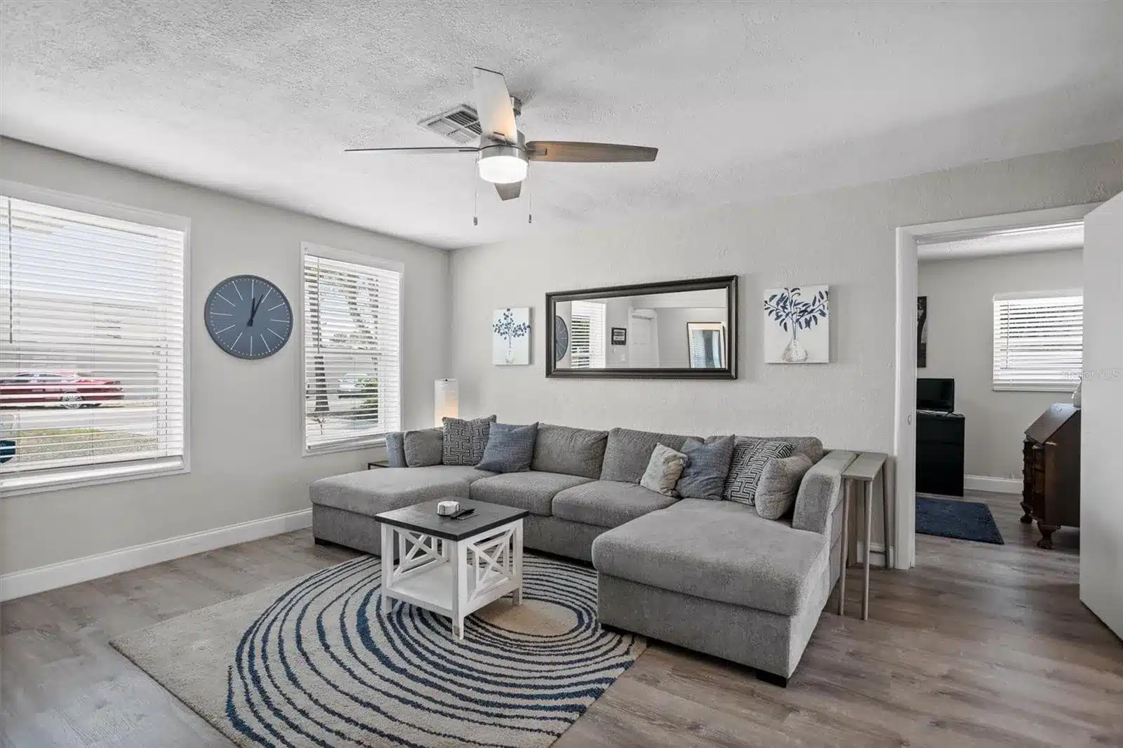 Living room with large gray sectional and round rug.