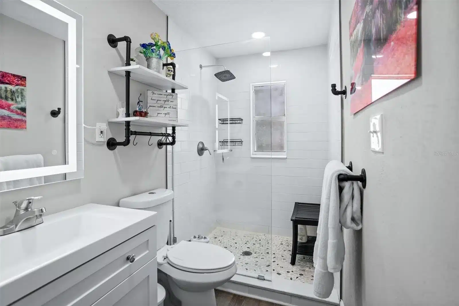 Modern bathroom with walk-in shower and white vanity.
