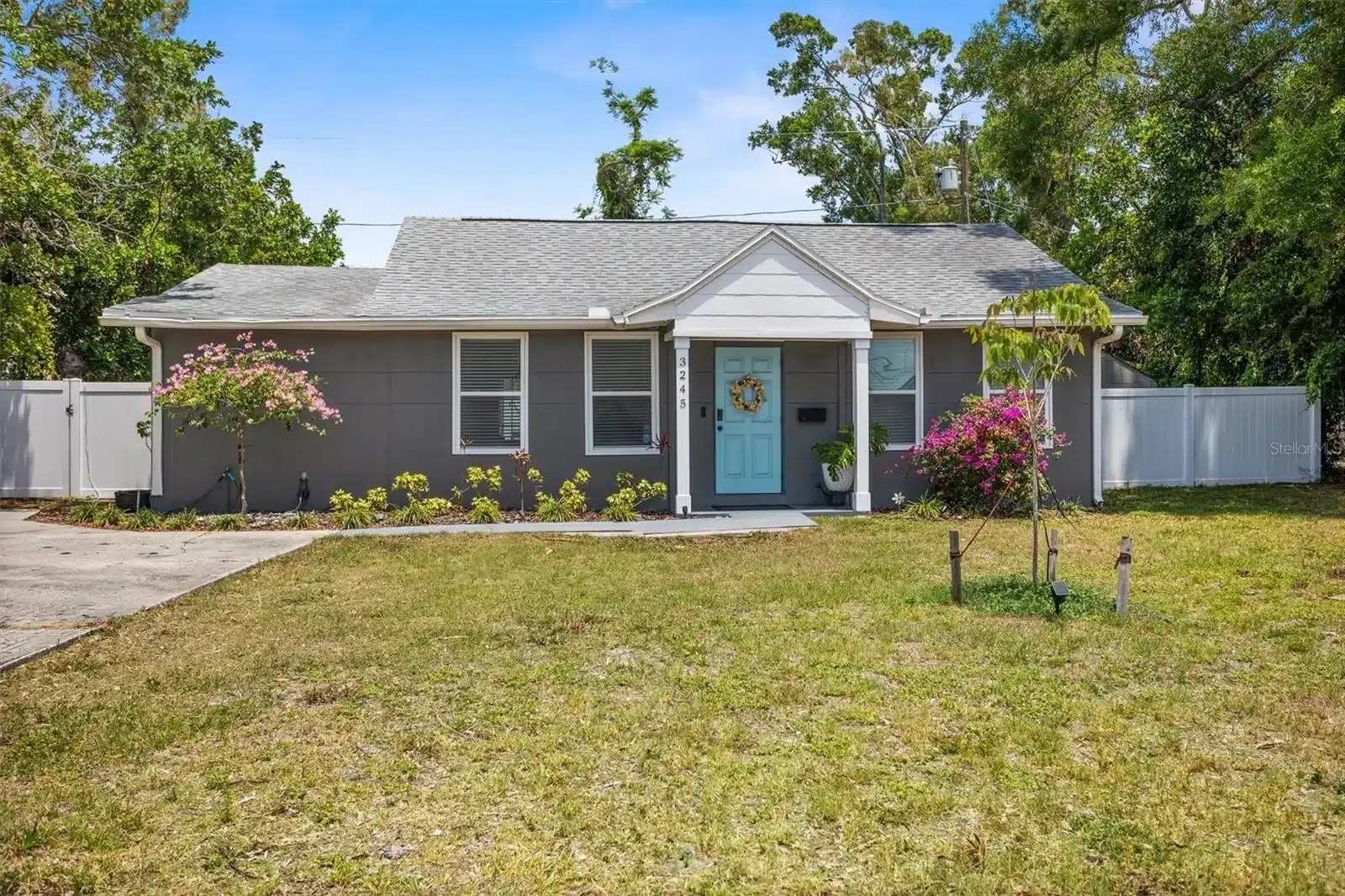 Exterior of a gray house with a light blue door.