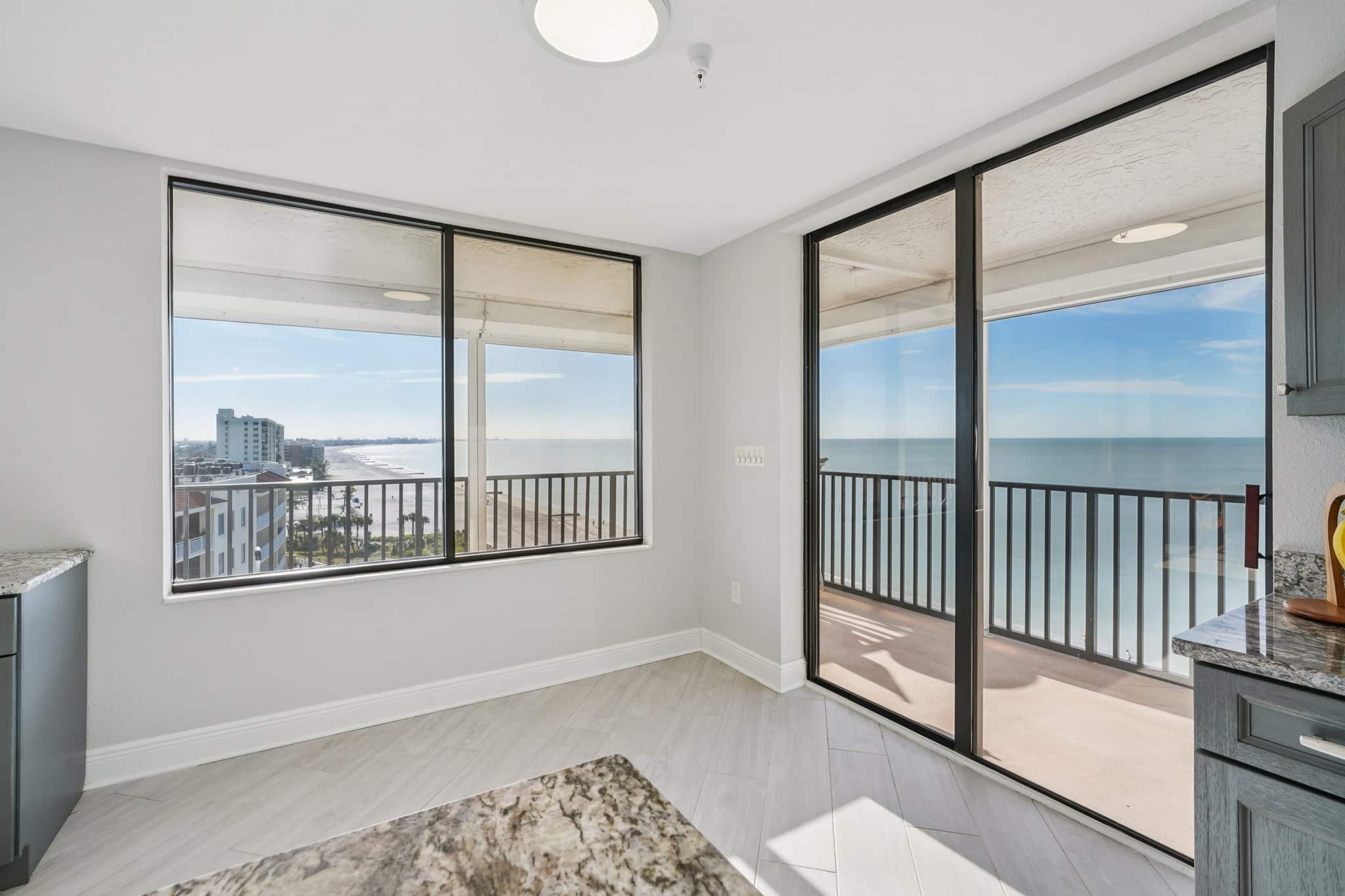 Dining area with large windows and balcony overlooking the Gulf of Mexico at 15316 Gulf Blvd Madeira Beach FL