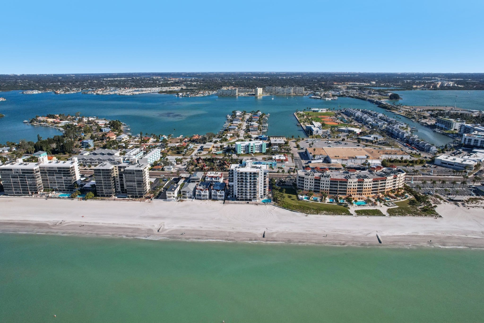 Aerial view of Madeira Beach FL showing beachfront condos, Gulf of Mexico, and intracoastal waterway near 15316 Gulf Blvd
