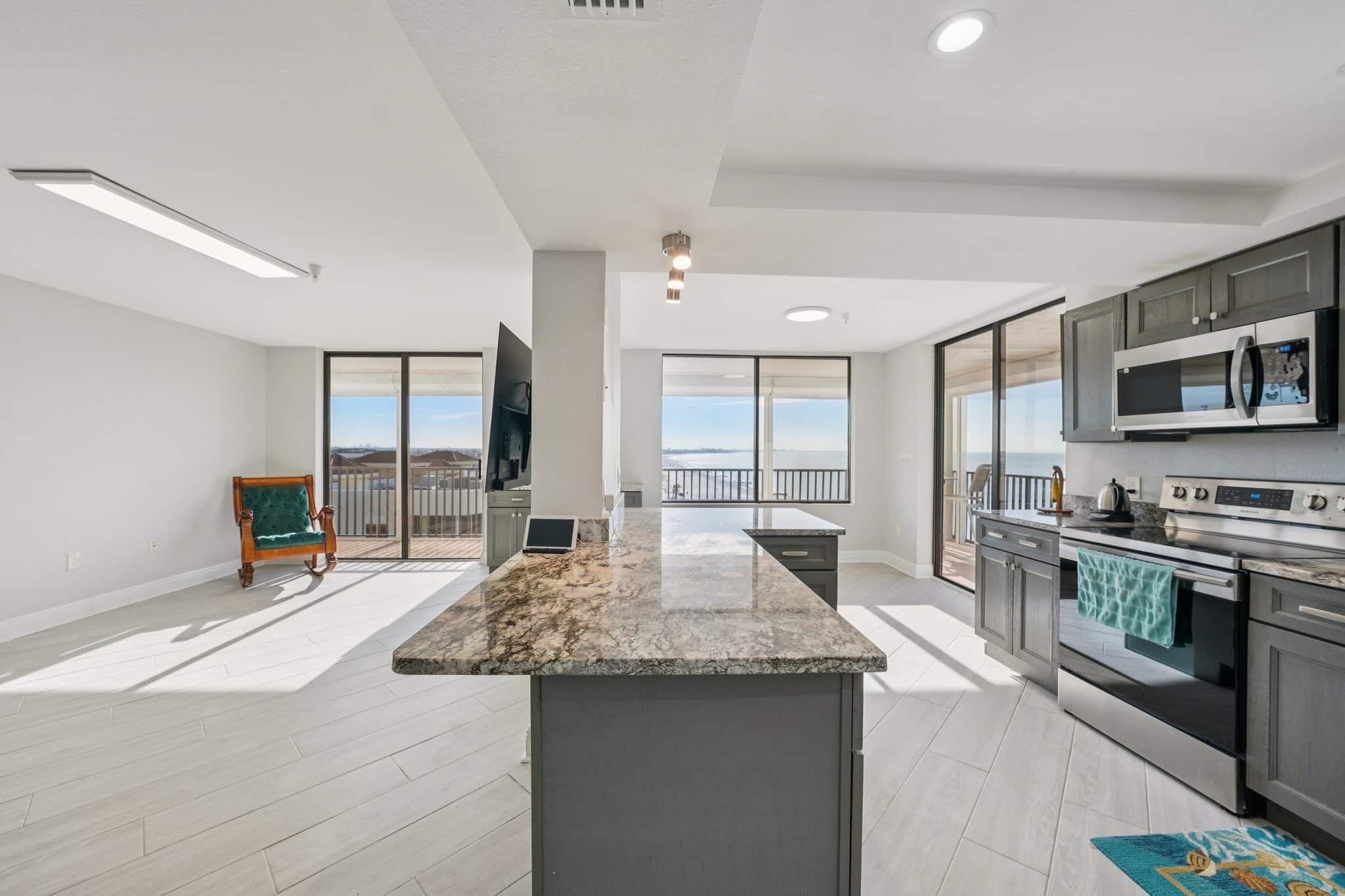 Open concept condo kitchen and living area with large windows and Gulf view balcony at 15316 Gulf Blvd Madeira Beach FL