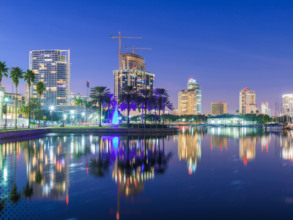 St. Petersburg city skyline at night with colorful lights reflecting on the water.